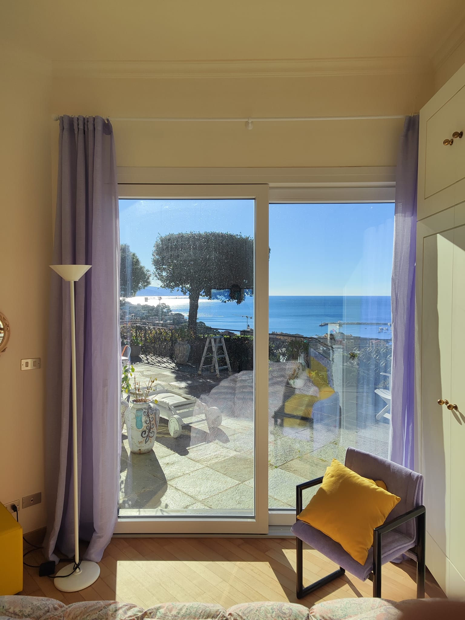 Ampia porta-finestra scorrevole con tende, affacciata su una terrazza